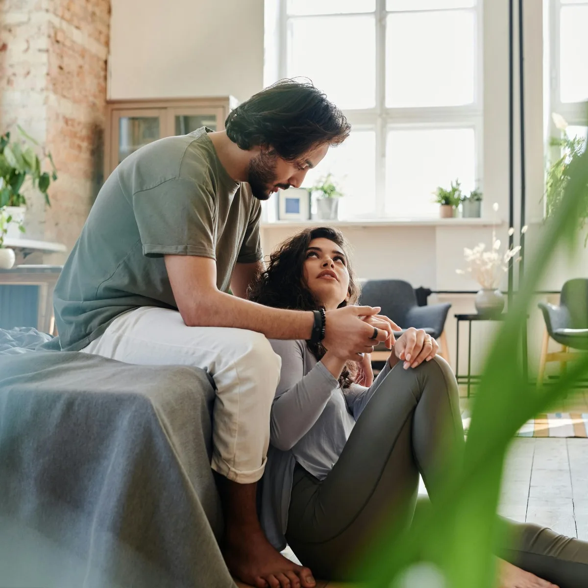 Cặp đôi nắm tay nhìn nhau trong phòng khách tình yêu đối diện với nỗi sợ bị phản bội