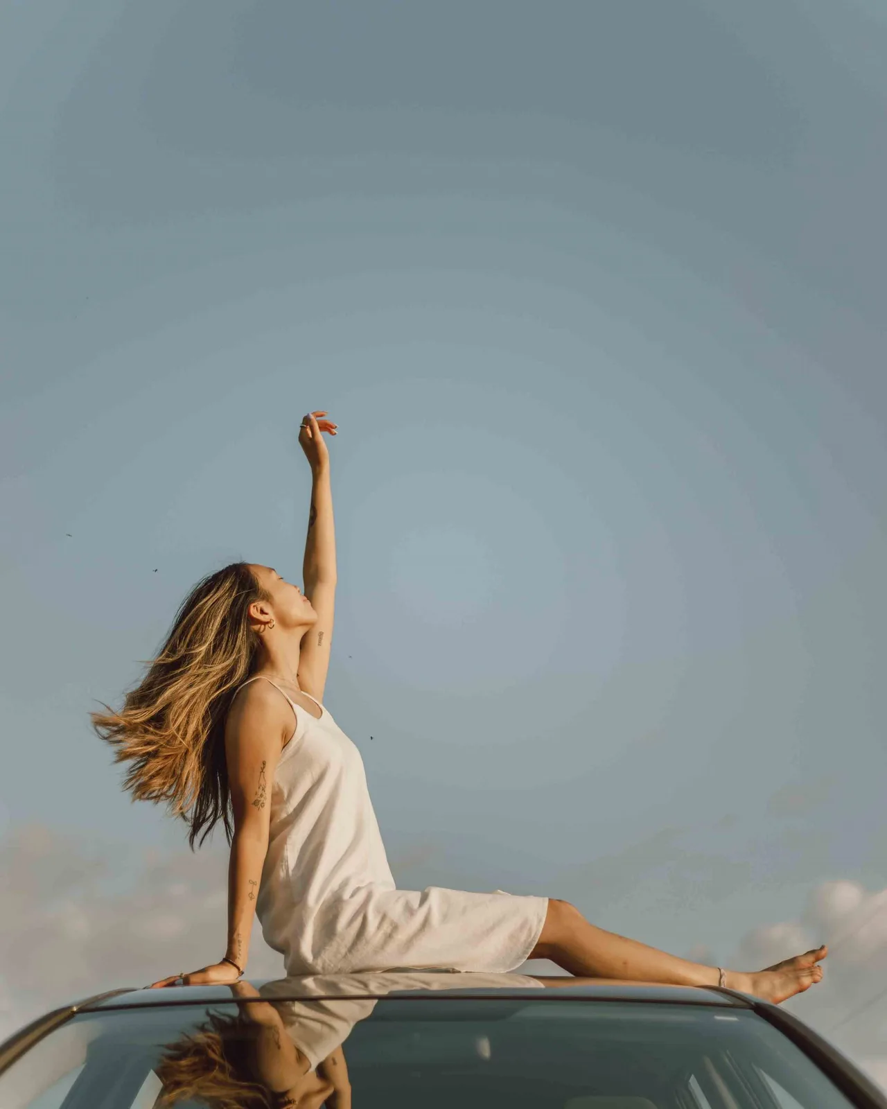 cô gái độc thân ngồi trên nóc ô tô jasmin chew unsplash