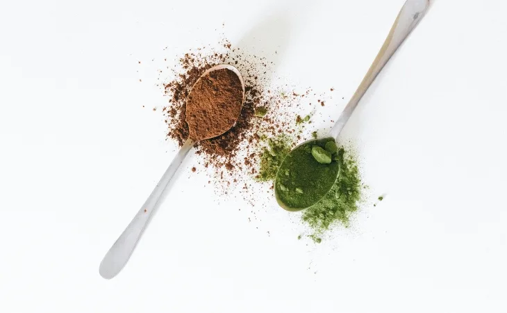muỗng bột cacao và bột matcha đặt bên cạnh nhau
