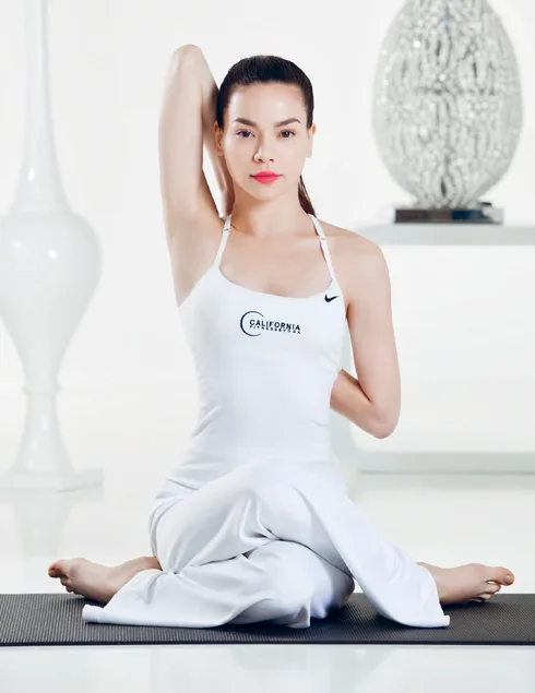 Từ từ bắt chéo chân phải đặt lên chân trái và đưa hai tay lên ngang vai
