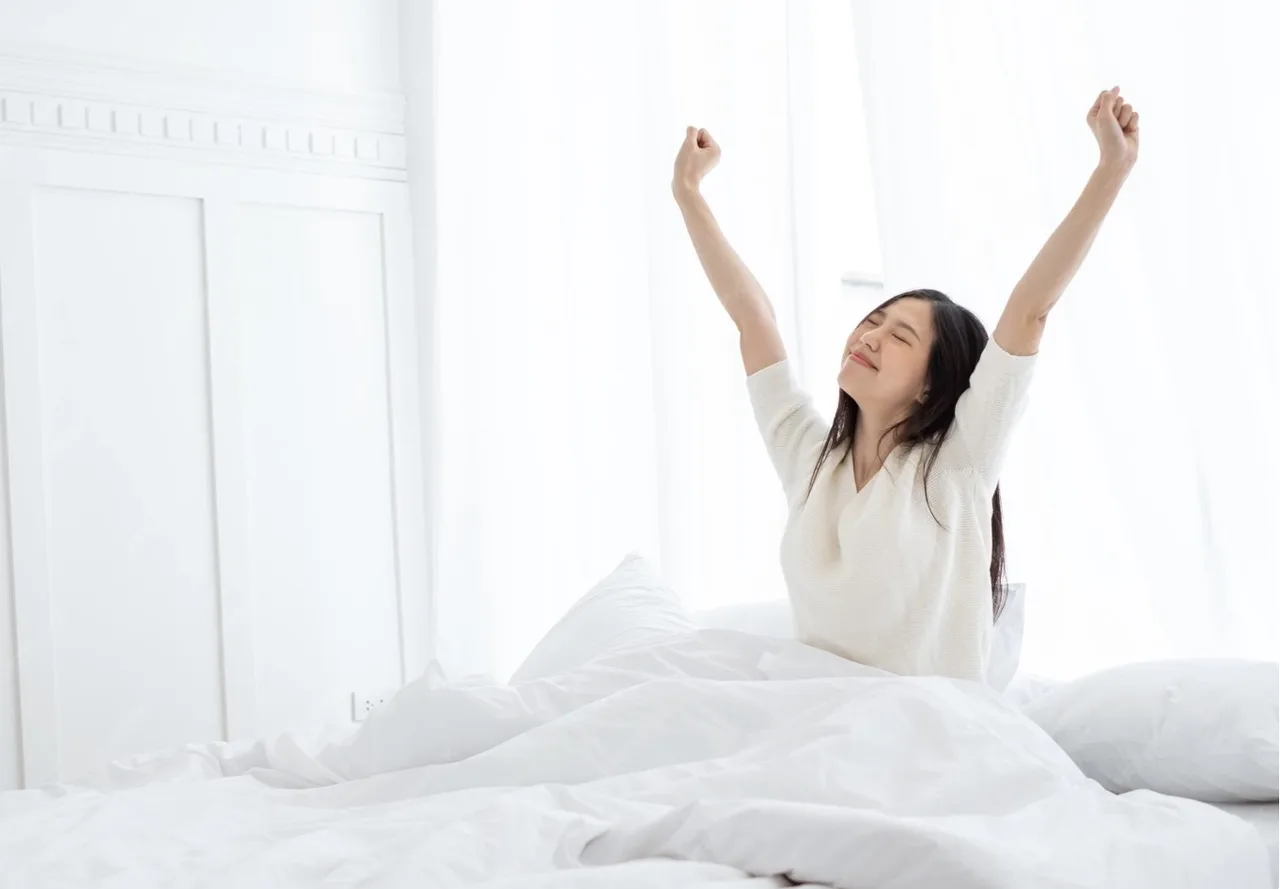 cô gái đang vươn vai trên giường