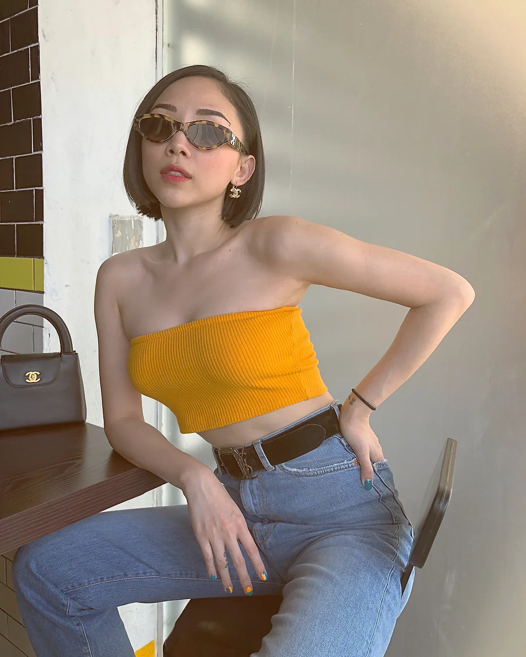 tóc tiên phối áo ống màu vàng với quần jeans và mắt kính