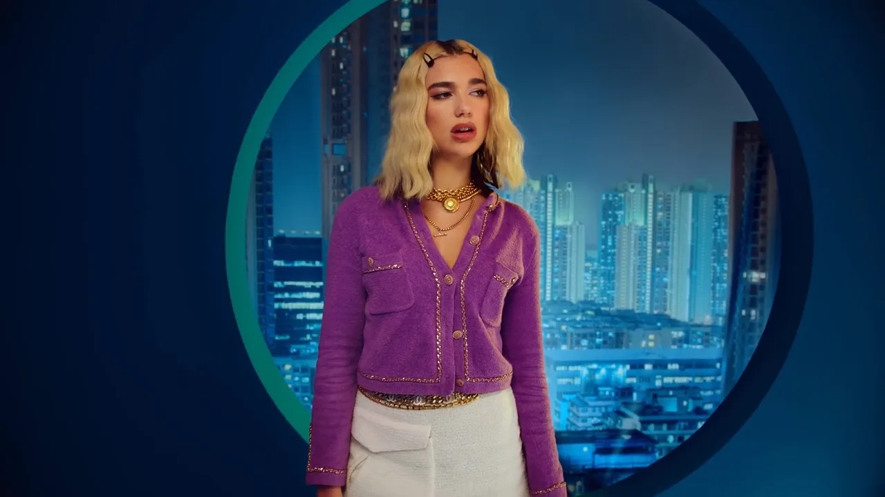 Dua Lipa mặc áo tím và chân váy ngắn, đeo vòng cổ xích vàng trong MV Break My Heart