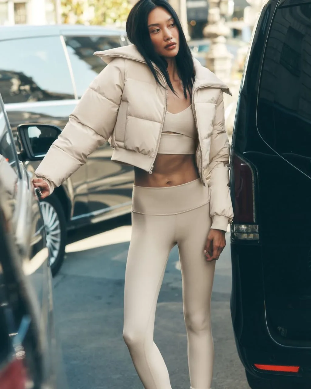 Bra top nude phối leggings đồng bộ, thêm áo khoác gió màu tone-sur-tone khoác hờ tạo hiệu ứng athleisure năng động.