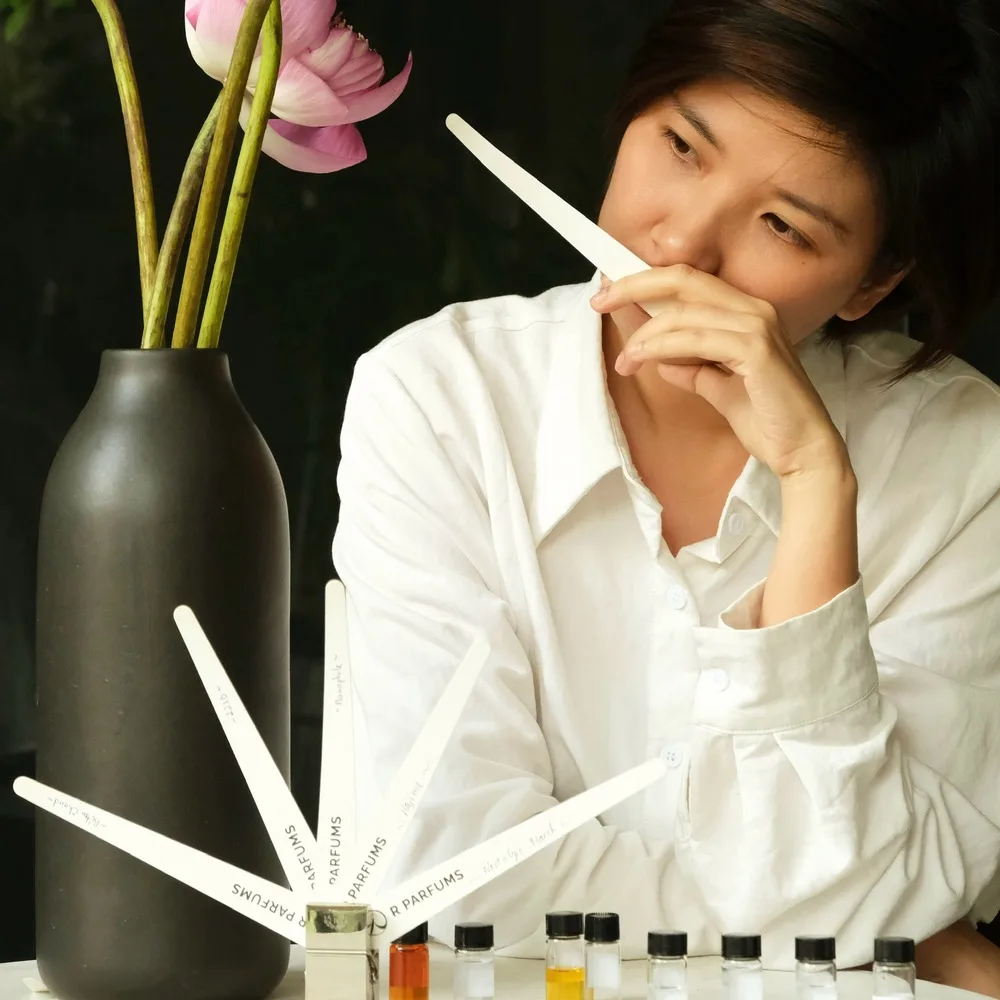 Rei Nguyễn chụp hình với nước hoa.
