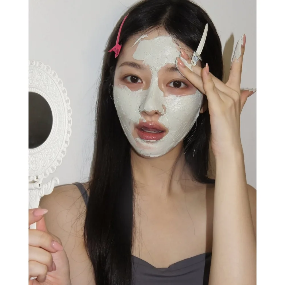 Cô gái đắp mặt nạ đất sét để loại bỏ mụn đầu đen.