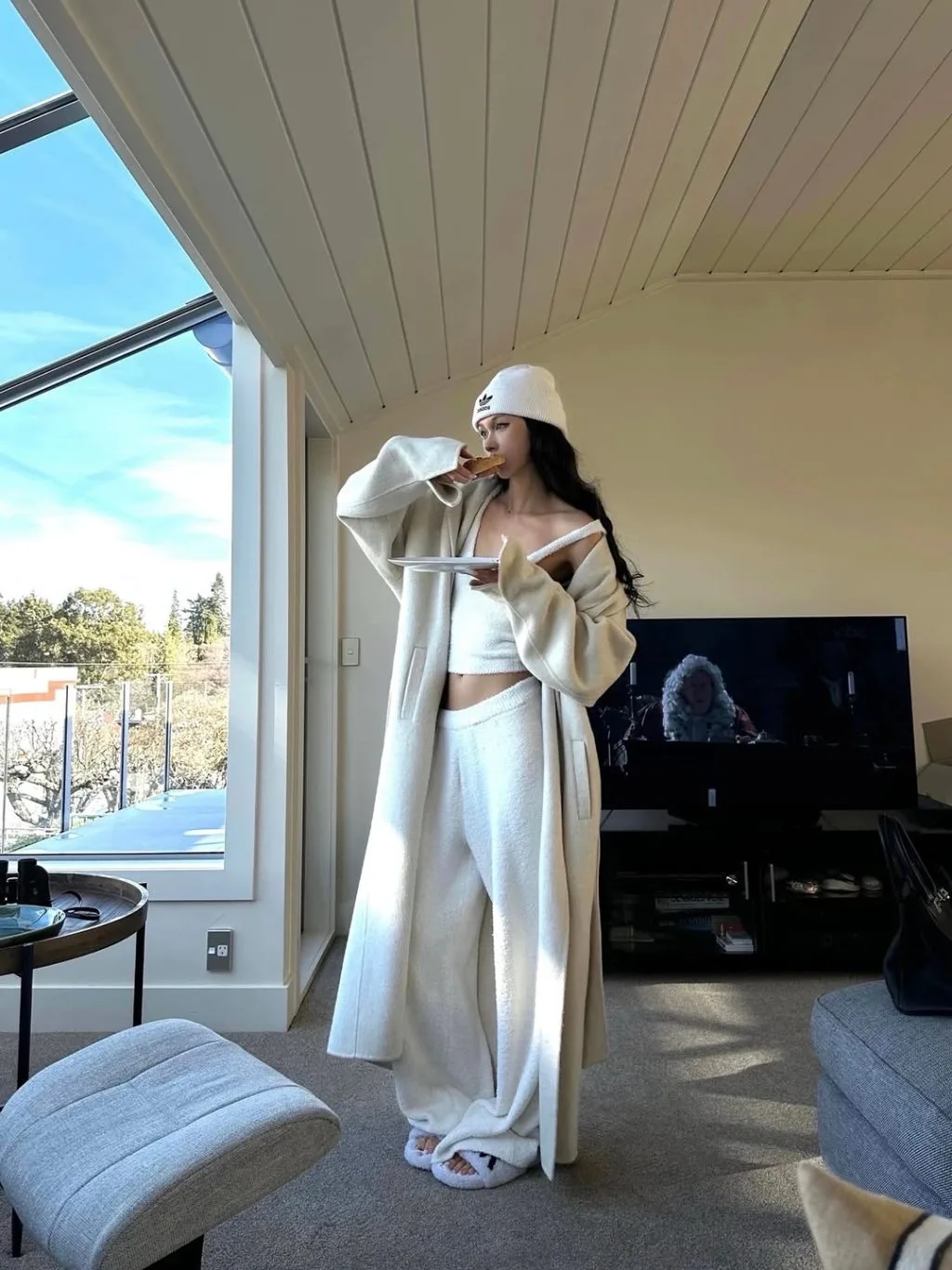 Một góc nhìn tối giản: măng tô màu beige, quần ống suông và giày thể thao trắng – công thức effortless chic hoàn hảo.