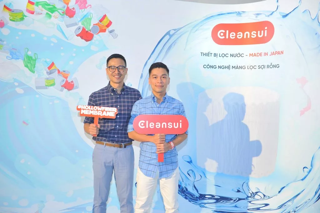 Cặp đôi Adrian Anh Tuấn và Sơn Đoàn tại quầy trải nghiệm sản phẩm lọc nước Mitsusbishi Cleansui cho phòng giặt.