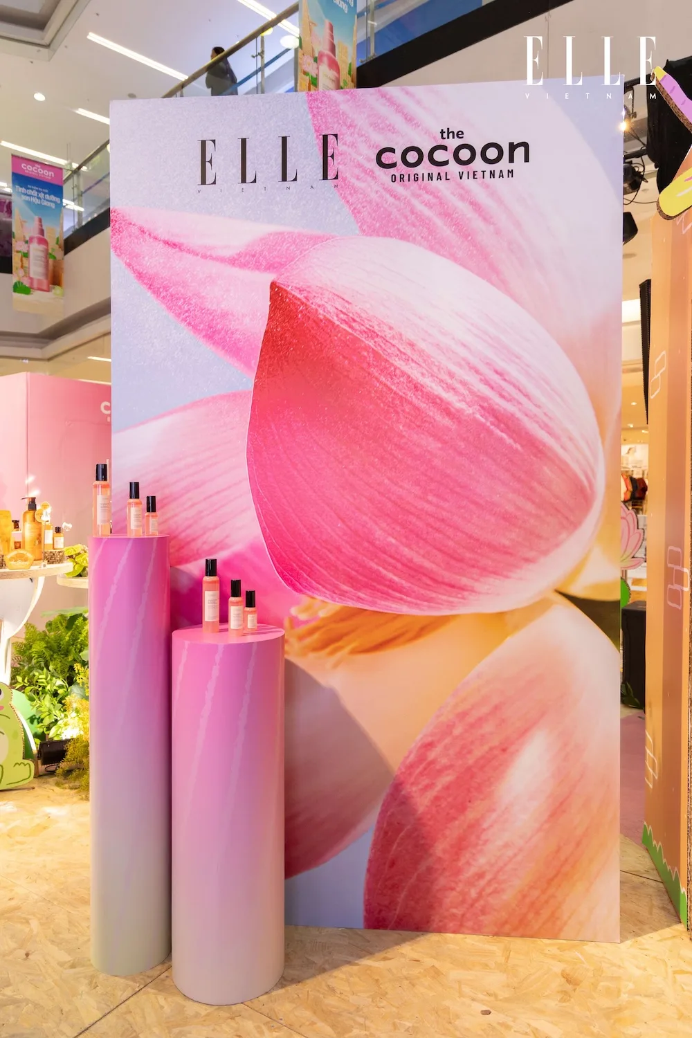 Backdrop cánh sen cùng khu vực trưng bày sản phẩm xịt dưỡng Cocoon.