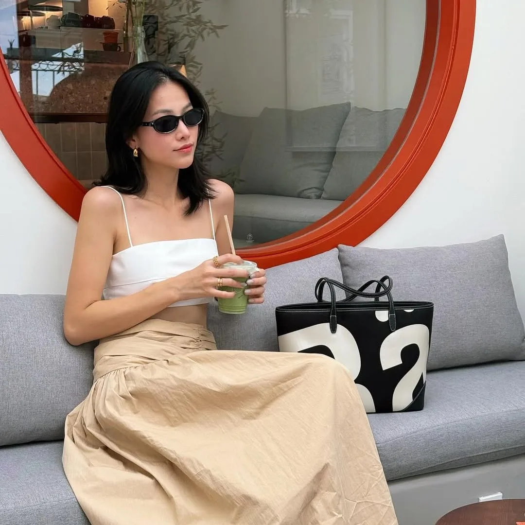 Phương Khánh ngồi trong quán cafe, phong cách tối giản, cầm ly matcha.