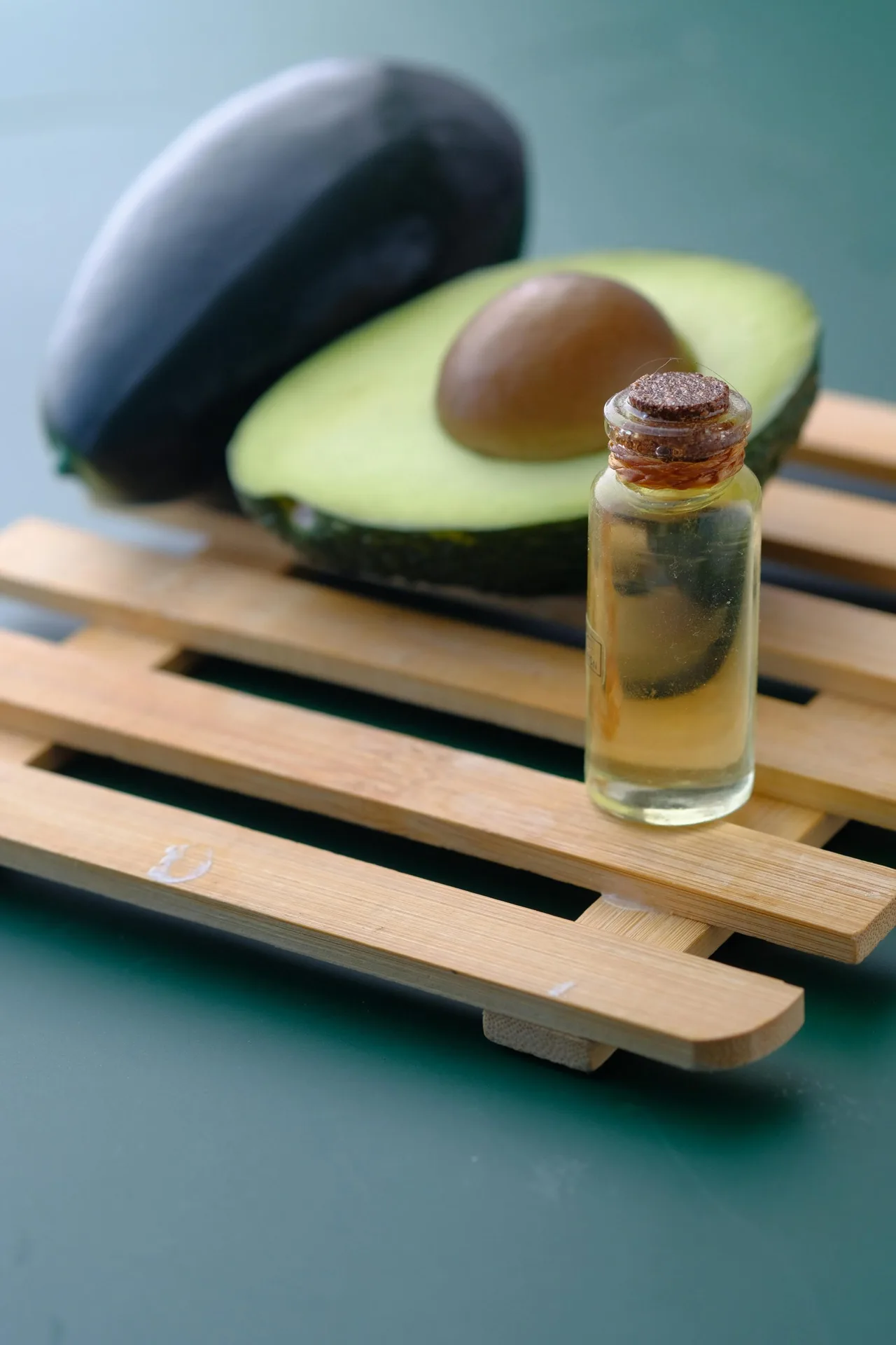 trái bơ được cắt đôi và lọ dầu ô liu ủ tóc