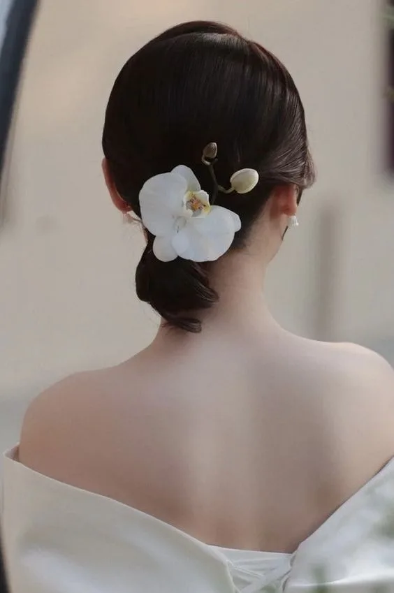 Tóc búi thấp đang được xem là kiểu tóc quốc dân mang lại cho cô dâu vẻ đẹp sang trọng, thanh lịch