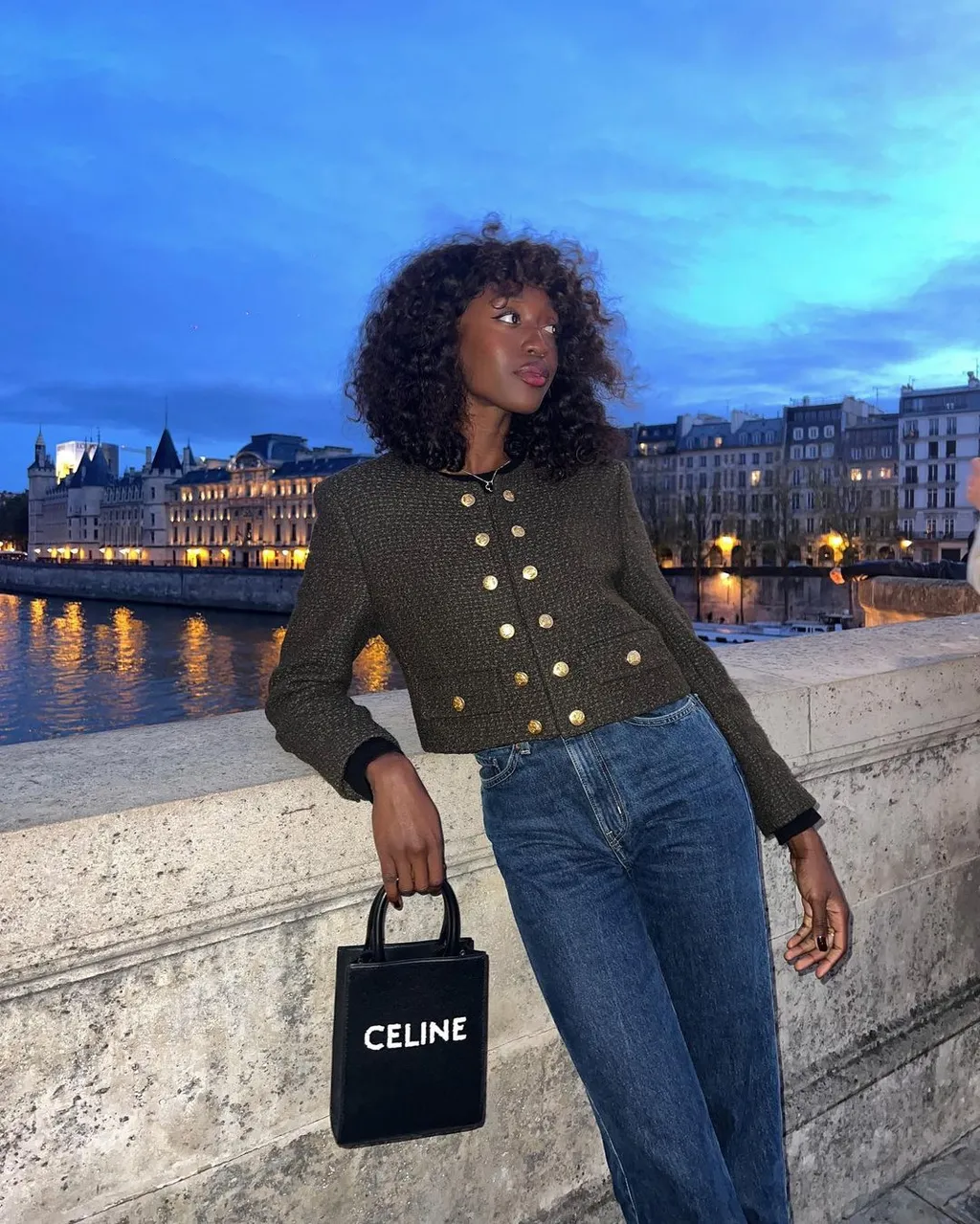 Một chiếc tweed jacket điểm nút ánh kim nổi bật trên chất denim trầm, mang lại cảm giác sang trọng nhưng không gò bó.