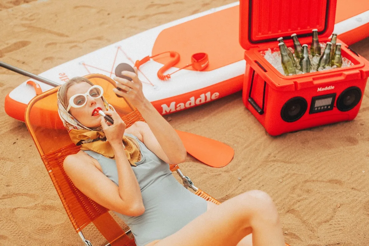 phụ nữ đang trang điểm và thoa son môi trên bãi biển triệt lông sạch láng mịn