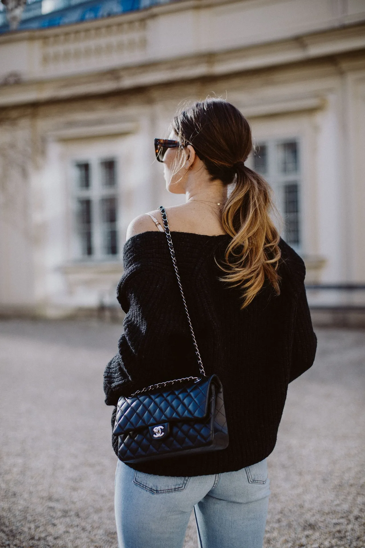 cô gái mặc áo đen tóc đuôi ngựa đeo túi Chanel classic flap bag