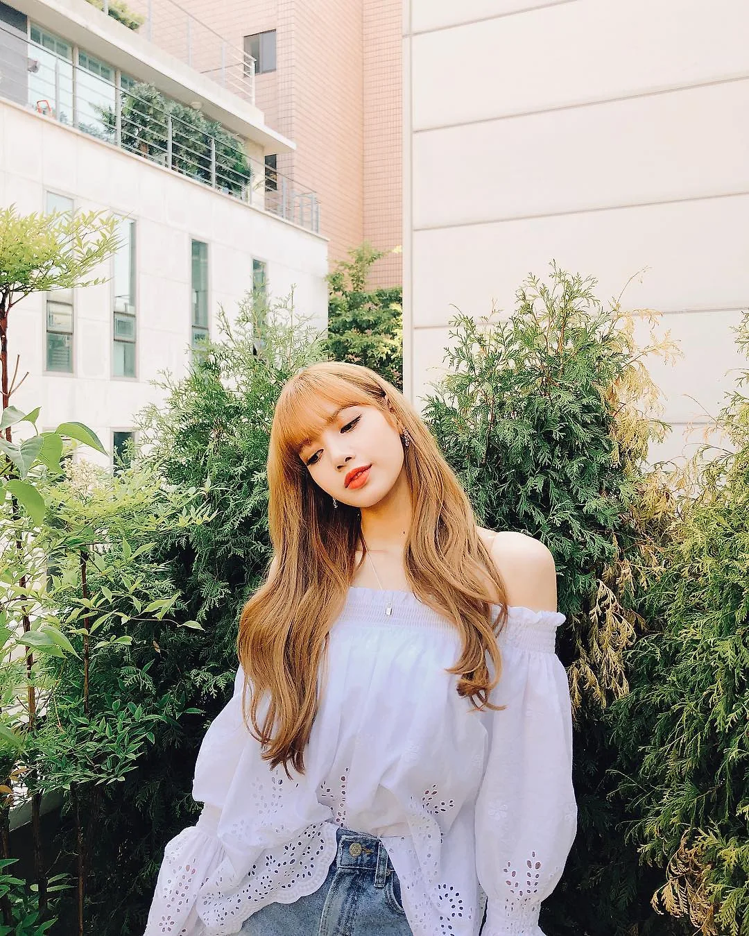 Lisa (Blackpink) mặc áo trễ vai màu trắng và quần jeans