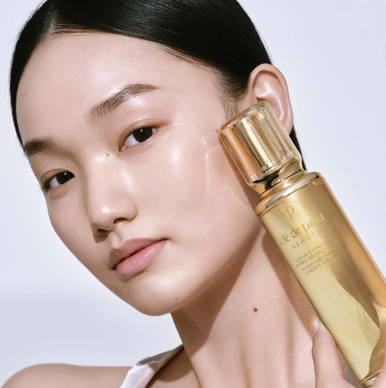 Hình ảnh cô gái với sản phẩm nước làm mềm da Hydro-Softening Essence.
