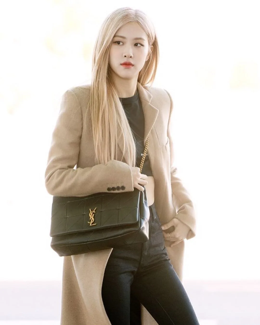 Rosé tóc vàng mặc áo khoác be áo đen quần đeo túi YSL