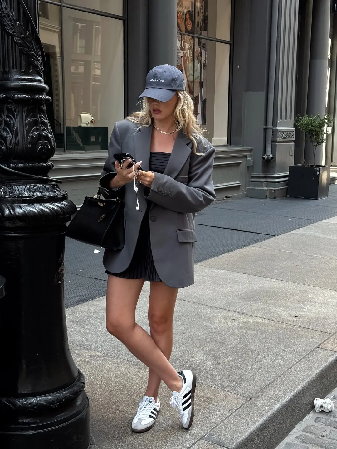 Áo blazer độn vai phom đứng khoác ngoài đầm mini-dress diện cùng sneakers cá tính.