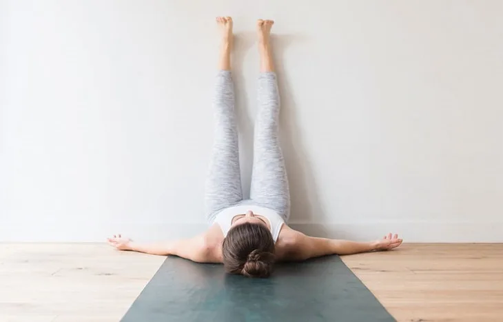 bài tập yoga - người phụ nữ gác chân lên tường bài tập yoga - người phụ nữ gác chân lên tường