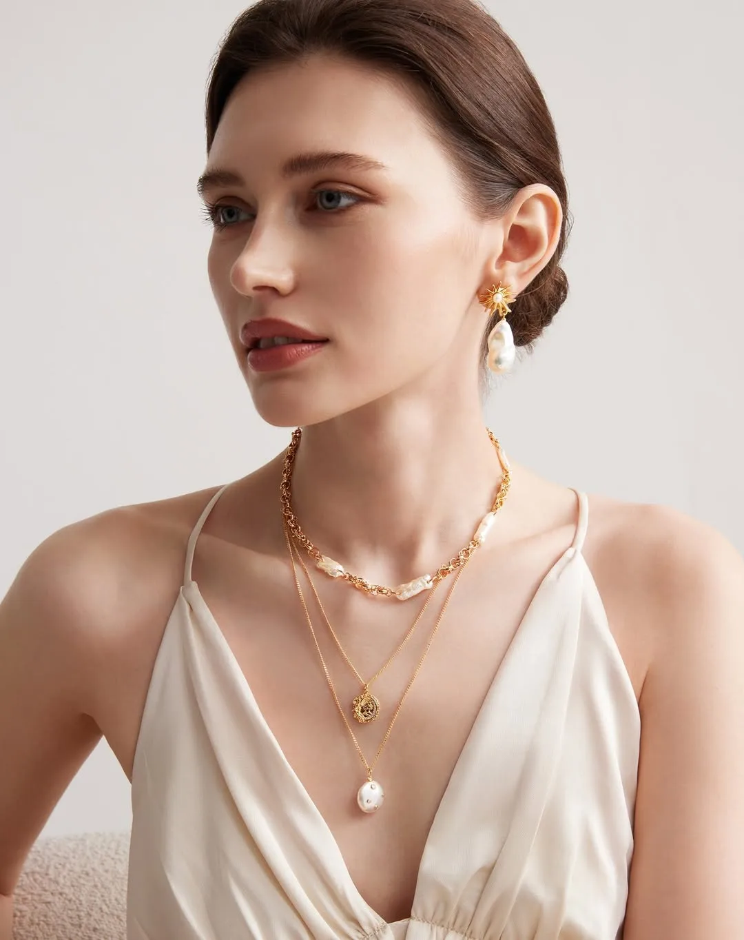 Đầm cổ chữ V nữ tính gấp đôi khi đi cùng dây chuyền ngọc trai.