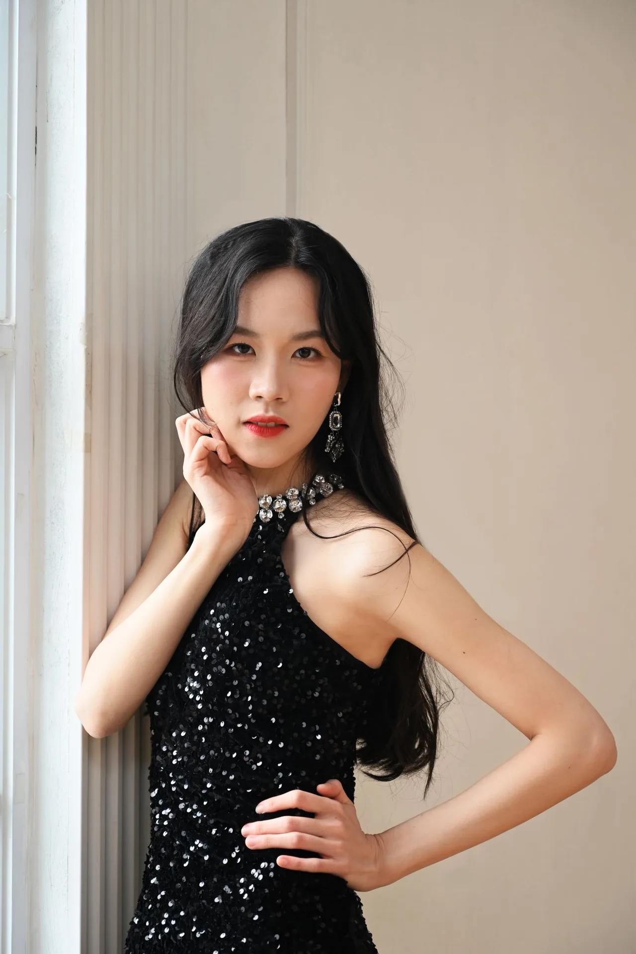 chị Hiền Trang rạng rỡ trong bộ váy đen tay chống cằm.