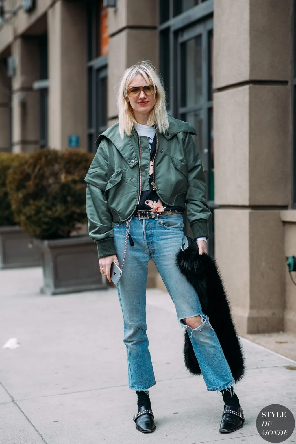 cô gái tóc vàng mặc khoác lửng và quần jeans rách