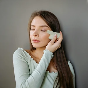 cô gái dùng đá guasha massage mắt