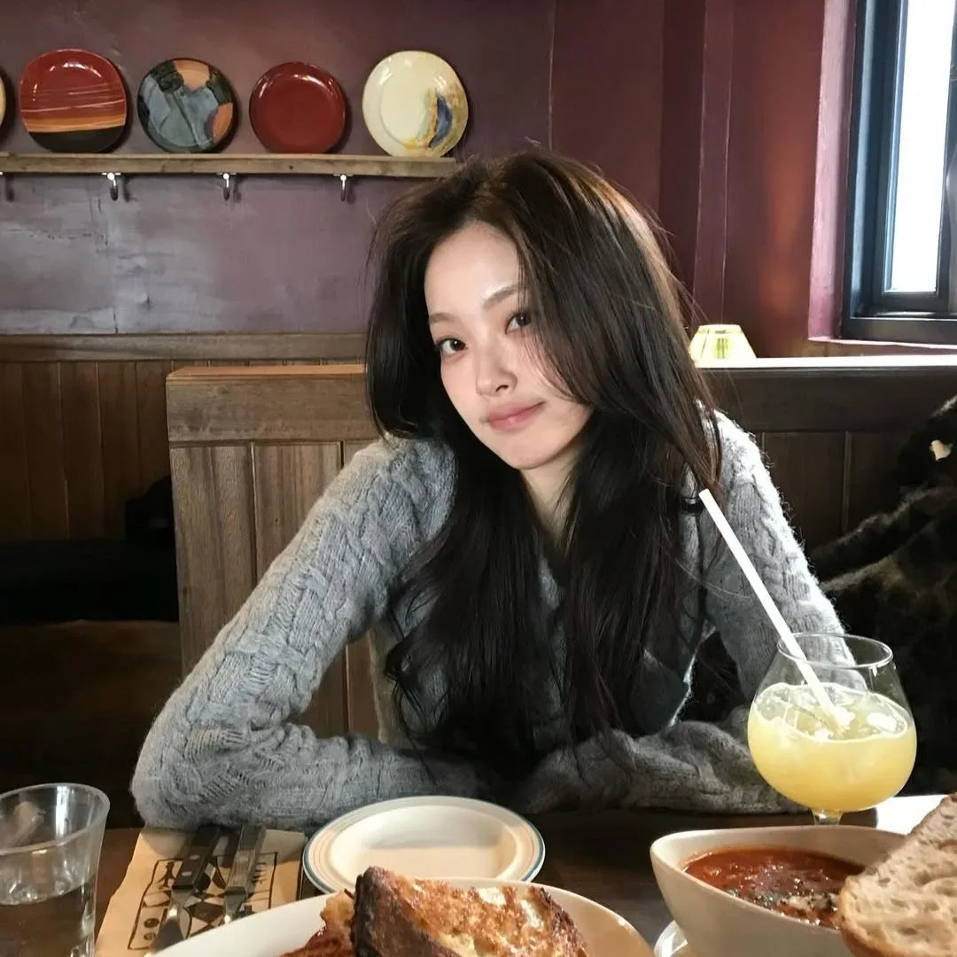 cô gái ngồi trên bàn ăn