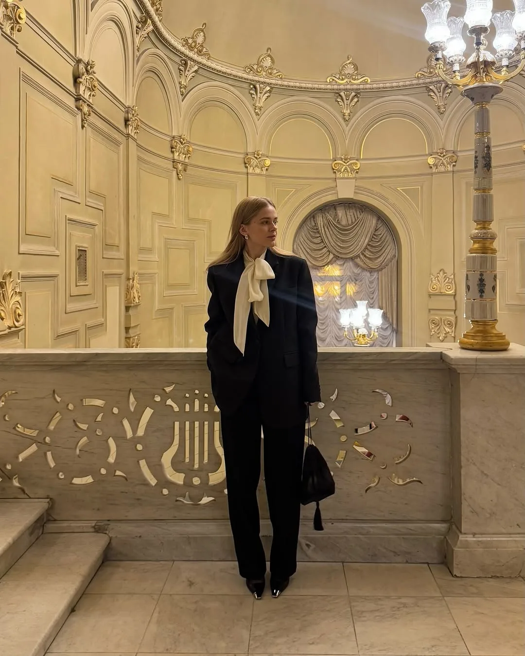 Biến tấu nơ lụa mềm mại làm mềm hóa cấu trúc mạnh mẽ của chiếc áo blazer.