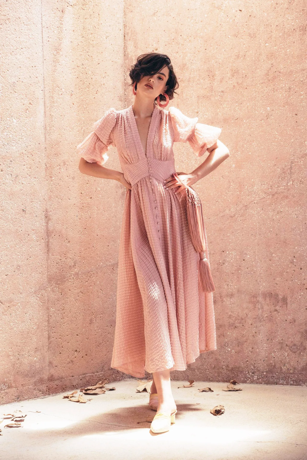 cô gái tóc ngắn mặc đầm dài tay phồng màu hồng thạch anh rose quartz đeo hoa tai đá tròn