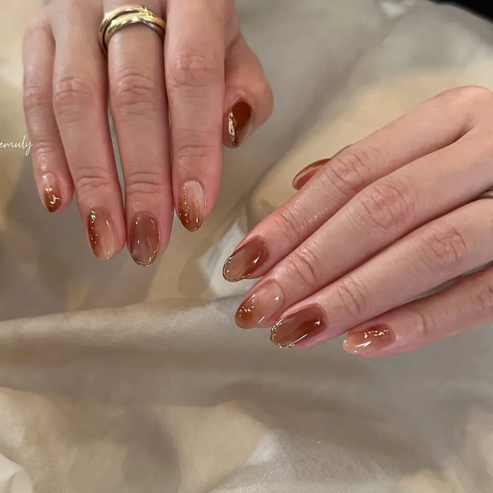 đôi tay với bộ nail nâu ombre