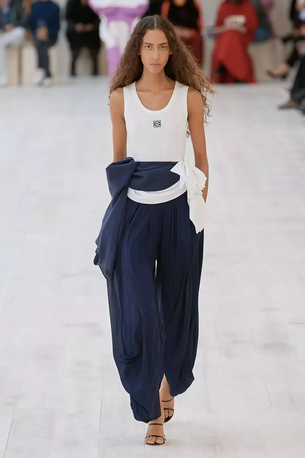 Áo tanktop trắng của Loewe Spring 2022 collection ready to wear phối với quần navy ống rộng sàn gỗ mẫu da ngăm