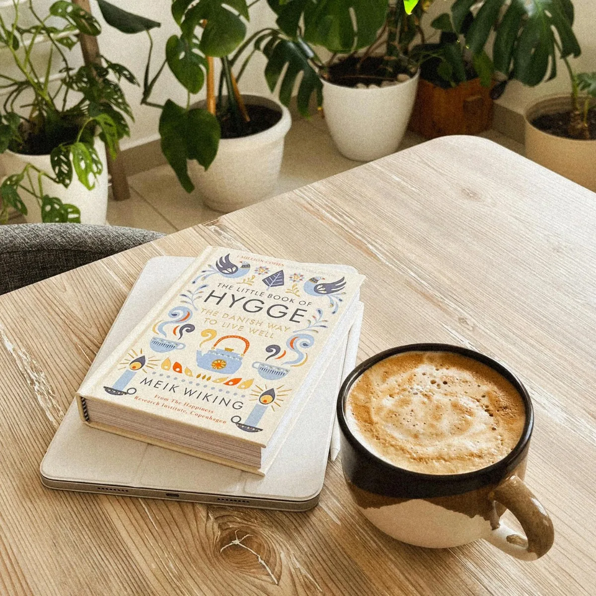Quyển sách Hygge và tách cà phê trên bàn