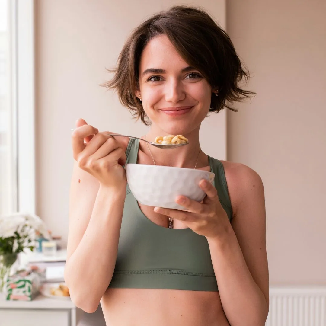 Người phụ nữ ăn ngũ cốc và trái cây – nguồn carbohydrate giúp bổ sung năng lượng cho cơ thể, tránh cảm giác thèm ăn truớc kỳ kinh
