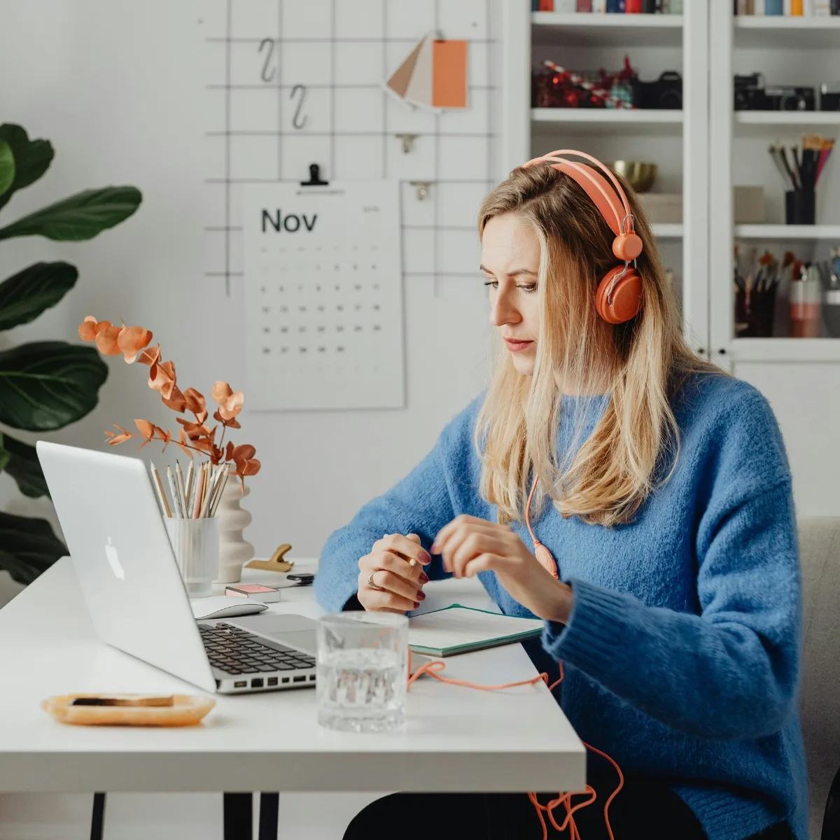 Cô gái đeo headphone màu cam trong phòng làm việc tràn đầy cảm hứng