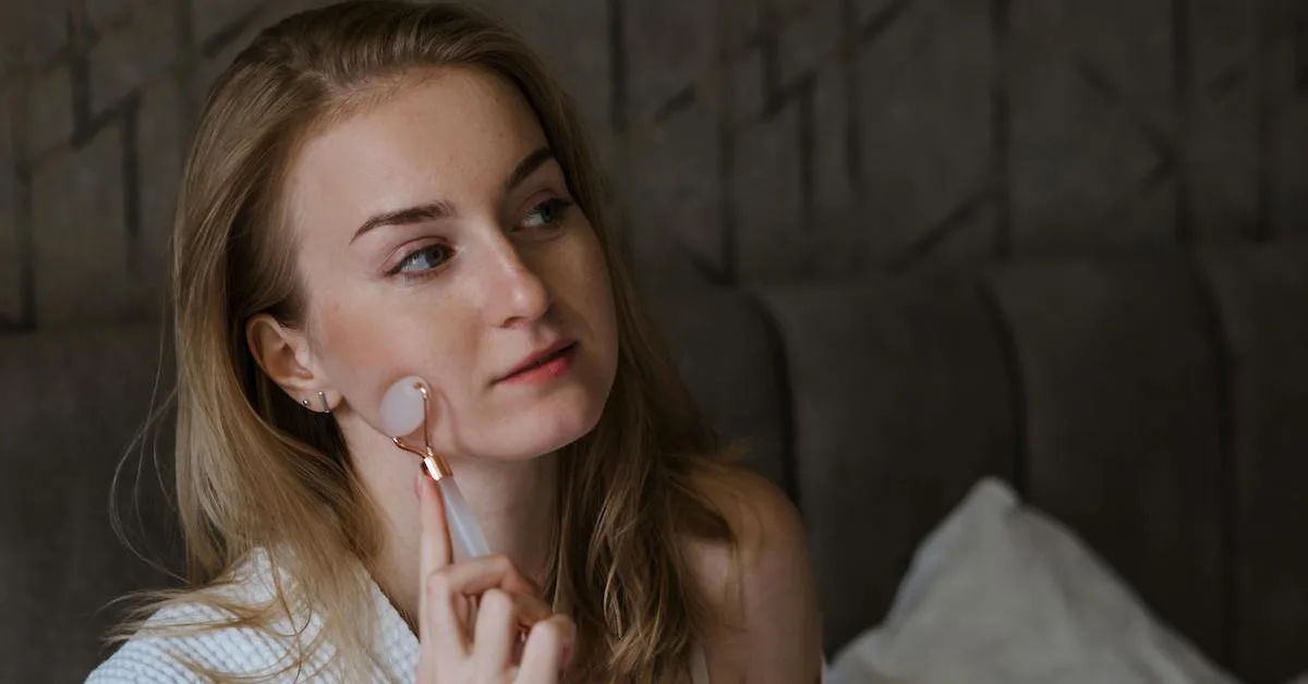 Cô gái sử dụng dụng cụ massage mặt trong chu trình chăm sóc da ban đêm