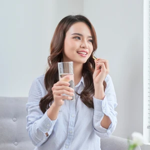 cô gái cầm ly nước uống vitamin tổng hợp