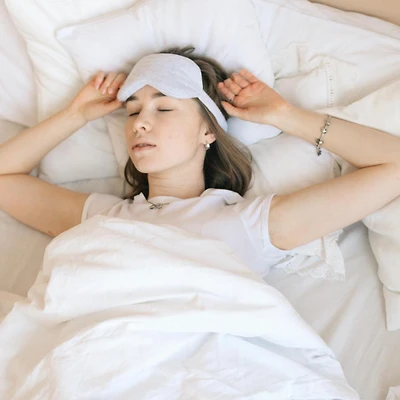 cô gái nằm trên giường ngủ, gối trắng