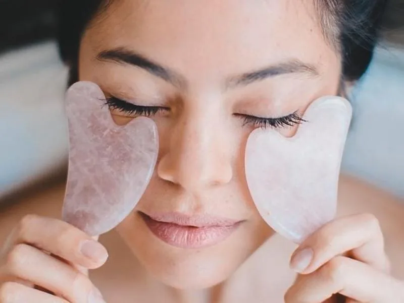 Massage Gua Sha với đá quý làm tăng độ đàn hồi cho da giúp da sáng mịn và căng bóng. Ảnh: Gettyimages. massage cho da mặt