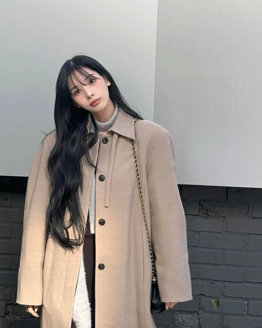 Layer độc đáo: áo len bên trong măng tô trench coat cổ điển, tạo hiệu ứng tương phản trẻ trung.