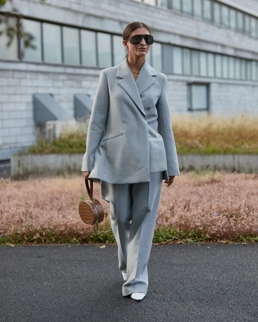 Fashionista mặc quần âu và áo blazer màu xanh cầm túi giả da cá sấu