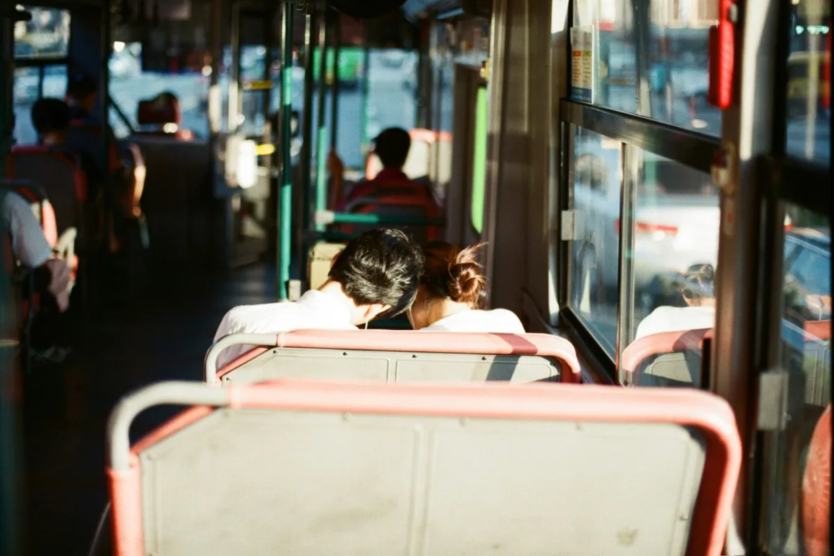 Cặp đôi ngồi cạnh nhau nghe nhạc trên xe buýt