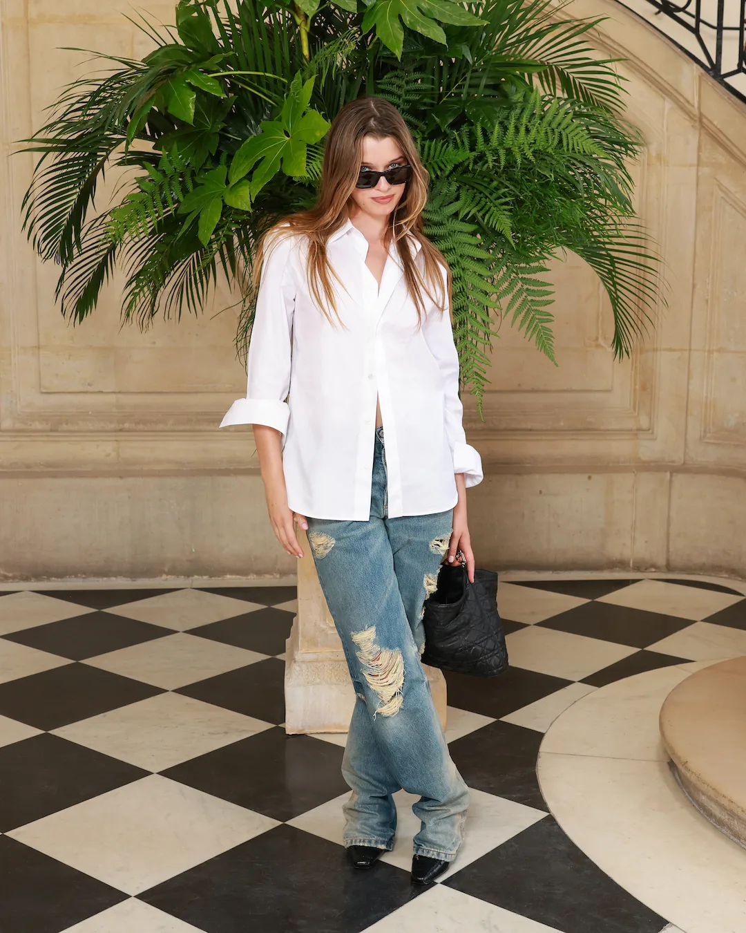 ver Anderson mang đến tinh thần gen Z năng động khi phối áo sơ mi trắng oversized thanh lịch cùng quần jeans dáng rộng mài rách bụi bặm.