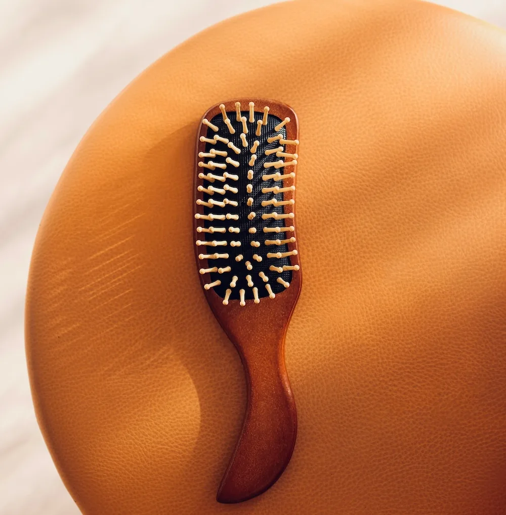Chiếc lược bàn dẹt bằng gỗ chuyên dụng để chải tóc và massage da đầu hằng ngày.