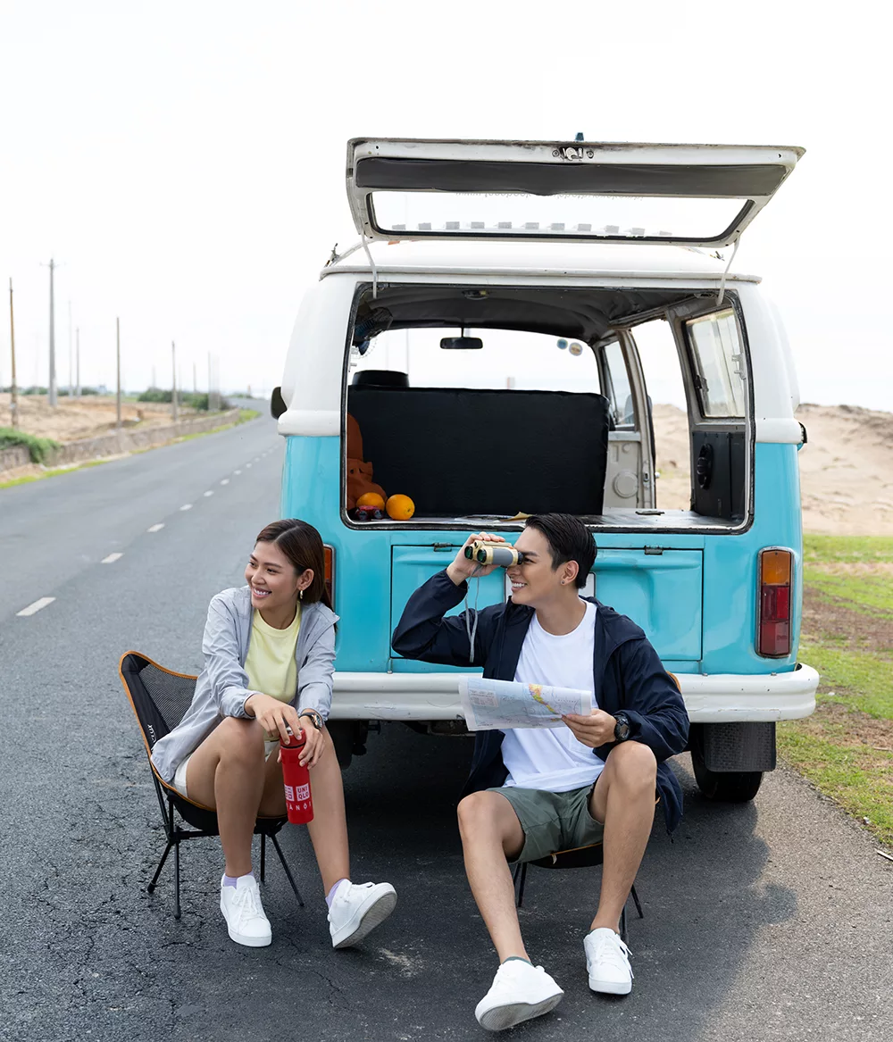 hai người mặc đồ thể thao ngồi đằng sau xe du lịch mùa hè