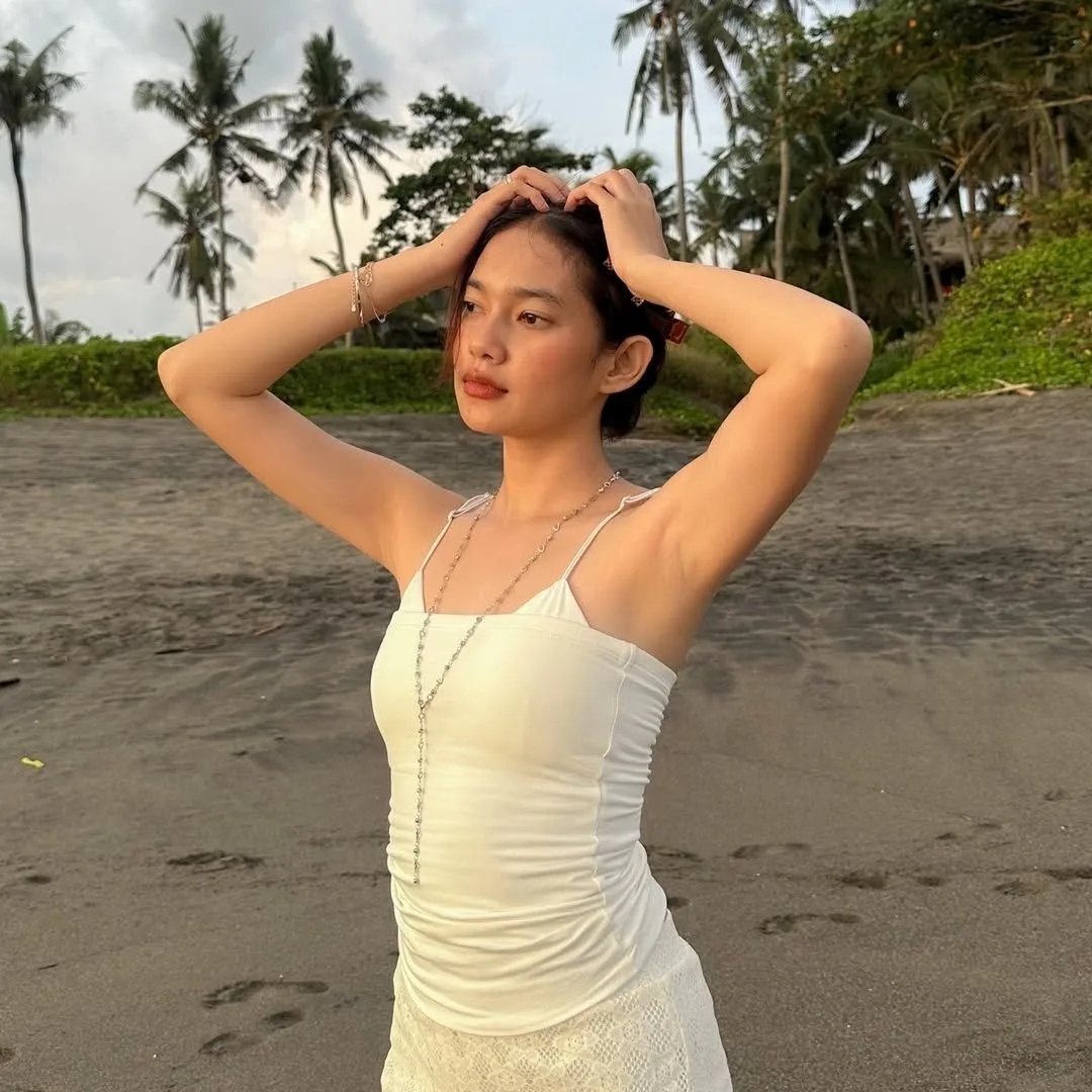 cô gái chụp hình dưới nắng ở bãi biển