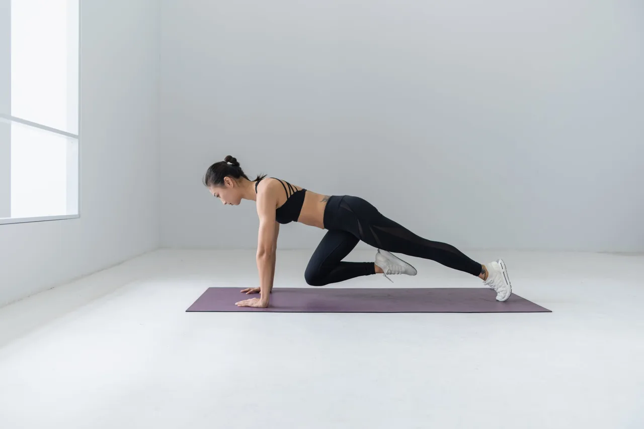 Tập thể dục giảm mỡ bụng-Cô gái thực hiện động tác plank đi bộ trên thảm. cô gái thực hiện động tác plank để giảm mỡ bụng