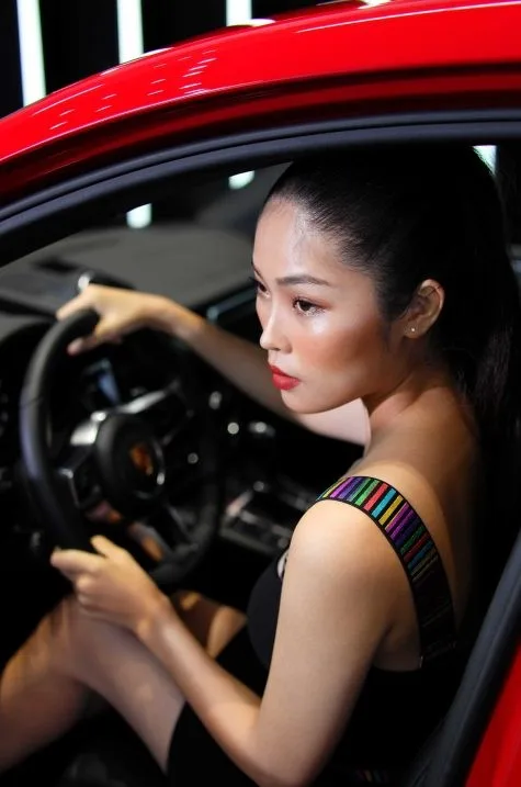 model nữ ngồi trong khoang lái xe porsche macan màu đỏ