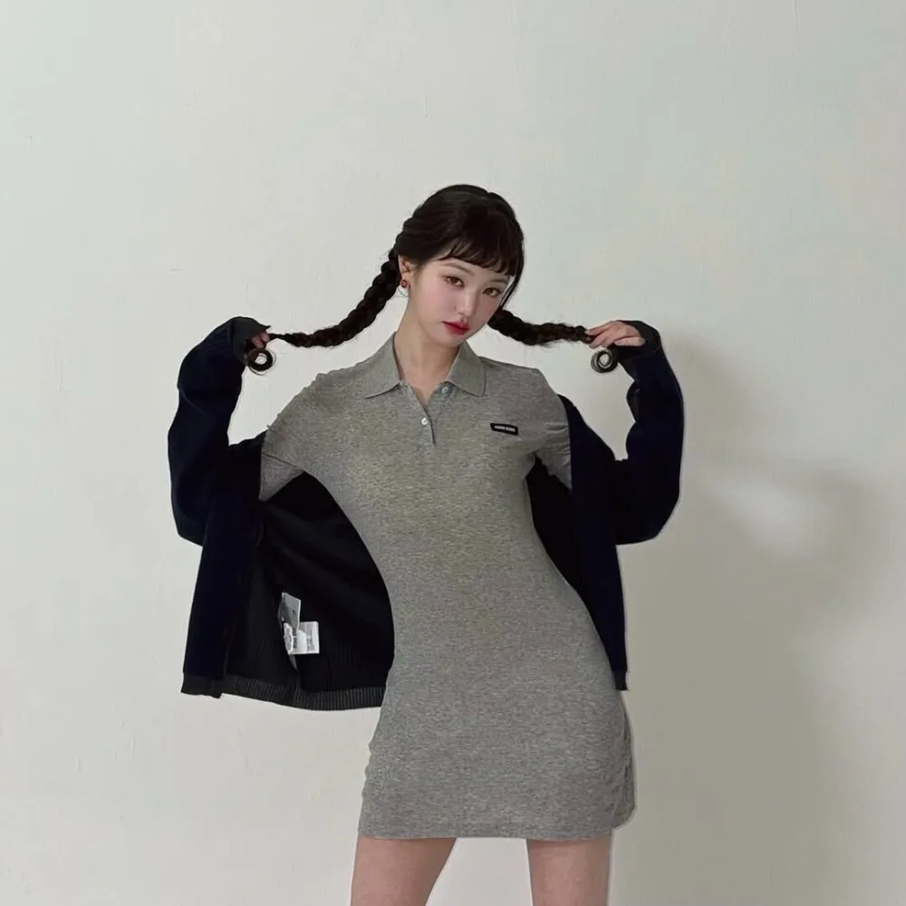 Jang Won-Young (IVE) mang váy thun xám đang cầm hai bím tóc.